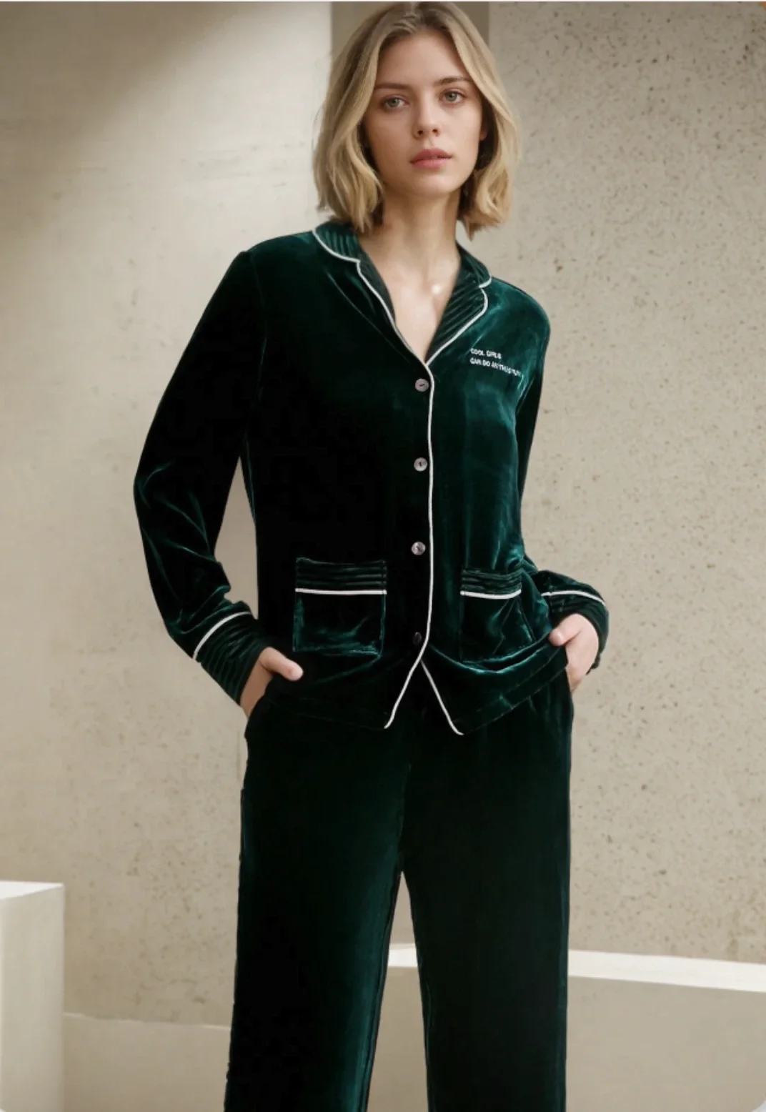 Woman wearing the dark green velvet pajama set with white piping
