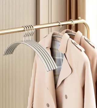 Pearl-nickel steel hangers holding coats on a brass rail