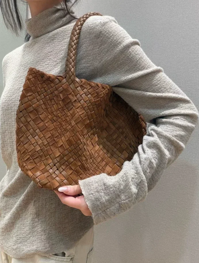 Woman carrying the cognac hand-woven leather tote on her shoulder